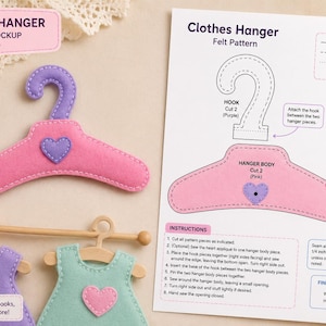 Pode incluir: Um cabide de feltro rosa com gancho e aplique de coração roxos, acompanhado de uma folha de instruções impressa intitulada Clothes Hanger Felt Pattern. A folha inclui diagramas de corte e costura, com um tamanho final de 14 cm por 9 cm.