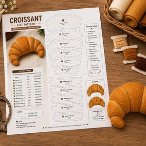 May include: A printable PDF sewing pattern for a felt croissant, featuring numbered pattern pieces, assembly instructions, and a diagram. The document includes a photo of a finished light brown felt croissant, measuring 5.1 inches wide.