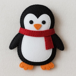 Pode incluir: Um pinguim de feltro feito à mão com corpo preto, barriga branca e cachecol vermelho. O pinguim tem pés e bico laranja, com olhos pretos de botão. As bordas são costuradas com linha branca, criando um design charmoso.