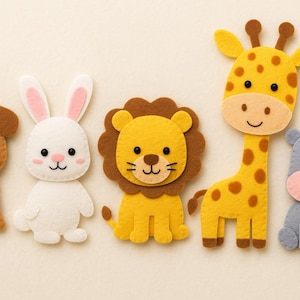 Puede incluir: Una colección de cinco figuras de animales de fieltro: un perro marrón, un conejo blanco, un león amarillo, una jirafa amarilla con manchas marrones y un hipopótamo gris. Cada figura tiene una cara sonriente.