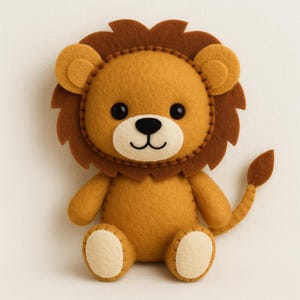 Può includere: Un peluche a forma di leone in feltro fatto a mano con corpo giallo dorato, criniera marrone scuro e dettagli color crema su viso, orecchie e piedi. Il leone presenta occhi a perla neri, naso ricamato e bocca curva, con una lunga coda.