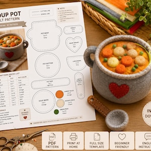 Puede incluir: Un patrón de fieltro para una olla de sopa que incluye instrucciones de costura, lista de materiales y diagramas de corte. Junto al papel hay una olla de sopa de fieltro gris con un corazón rojo, llena de verduras y un cucharón.