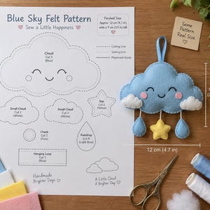 May include: A Blue Sky Felt Pattern sewing sheet with instructions and a finished blue cloud ornament featuring a yellow star and blue raindrops. The pattern includes text, diagrams, and dimensions of 12 cm by 9 cm (4.7 in by 3.5 in).
