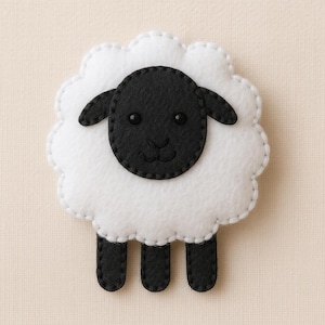 Puede incluir: Una oveja de fieltro hecha a mano con cara, orejas y patas negras, y un cuerpo blanco y esponjoso. La oveja tiene un contorno cosido y pequeños ojos de cuentas negras. Ideal para la decoración de la habitación de los niños.