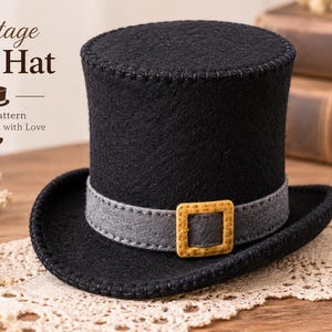 Pode incluir: Uma cartola de feltro preta com uma faixa cinzenta e uma fivela quadrada amarela. O texto na imagem diz Vintage Top Hat, Felt Pattern, Handmade with Love. O chapéu tem costuras visíveis ao longo das bordas da copa e da aba do chapéu.