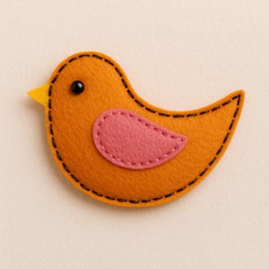 Op de afbeelding: Een handgemaakte vogel van vilt in oranje, roze en geel. De vogel heeft een roze vleugel, een gele snavel en een zwart oog. De randen zijn gestikt met zwart garen, wat een charmant, grillig ontwerp creëert.