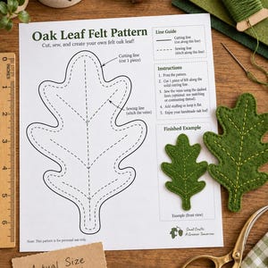Könnte beinhalten: Ein weißes Blatt Papier mit dem Titel Oak Leaf Felt Pattern, einer schwarzen Umrisszeichnung eines Eichenblatts, Nähanleitungen und einem fertigen Beispiel. Enthält ein 15 cm langes Holzlineal, grünen Filz, Garn und eine goldene Schere.