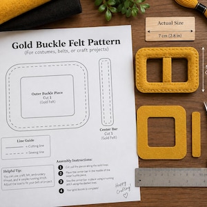 May include: A Gold Buckle Felt Pattern instruction sheet with diagrams, assembly steps, and a line guide. Includes two mustard yellow felt buckle pieces, a metal ruler showing 10 cm or 4 inches, and a wooden block labeled 7 cm (2.8 in).