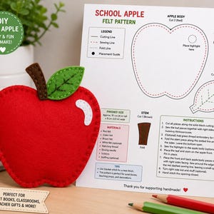 Pode incluir: Uma maçã de feltro vermelha com caule castanho e folha verde, exibida ao lado de uma folha de instruções impressa intitulada School Apple Felt Pattern. A folha inclui diagramas, uma lista de materiais e instruções passo a passo para a montagem.