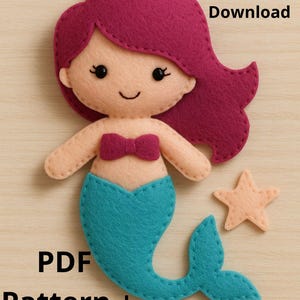 Könnte beinhalten: Filz-Meerjungfrauenpuppe mit türkisfarbenem Schwanz, magentafarbenem Oberteil und Haaren sowie einem pfirsichfarbenen Gesicht und Seestern. Der Text "Delivery Download" und "PDF Pattern + Tutorial" sind sichtbar.