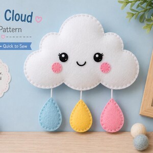 May include: A white felt cloud with a smiling face, black eyes, and pink cheeks, featuring three hanging felt raindrops in light blue, yellow, and pink. The text reads Baby Cloud Felt Pattern, Easy Cute Quick to Sew, and Perfect for nursery decor.