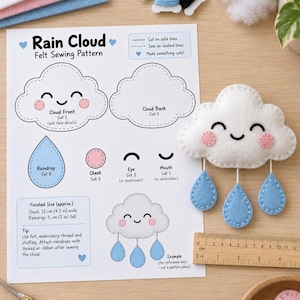 May include: A Rain Cloud felt sewing pattern sheet with printed instructions and diagrams, accompanied by a finished white felt cloud plushie with three blue felt raindrops. A wooden ruler shows the cloud is approximately 4.7 inches wide.