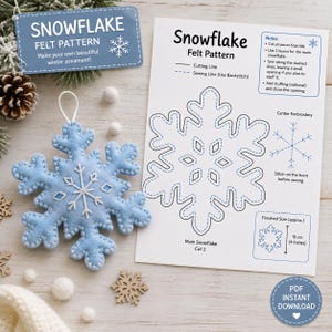 Pode incluir: Um ornamento de floco de neve em feltro azul claro com detalhes bordados em branco e um laço para pendurar, acompanhado por uma folha de instruções intitulada Snowflake Felt Pattern, incluindo diagramas, notas de costura e um guia de tamanho de 10 cm.