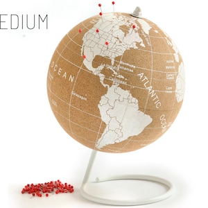 May include: A cork globe with a white base and a white map of the world. The globe is decorated with red push pins. The word "MEDIUM" is printed in black at the top of the image.