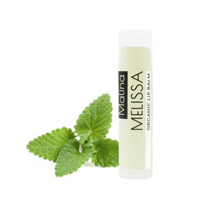 May include: A white tube of Melissa organic lip balm with a green leaf design. The tube is labeled "Malina Melissa Organic Lip Balm".