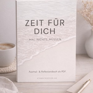 May include: A white book with the title "ZEIT FÜR DICH" and the text "MAL. NICHTS. MÜSSEN." and "Ausmal- & Reflexionsbuch als PDF" on the cover. The cover shows a beach scene. A cup of coffee and a pen are also visible.