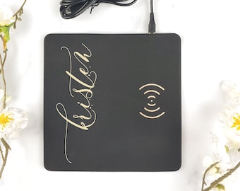 May include: Black leather wireless charging pad with a gold inscription that reads "Kristen".