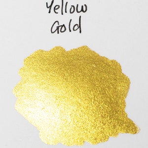 May include: A close-up of a gold ink sample with a shimmery finish. The ink is labeled "Yellow Gold".