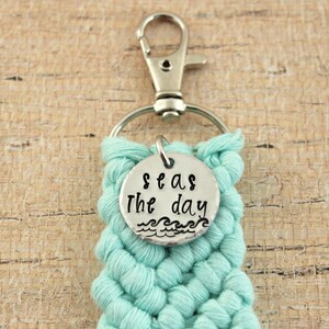 May include: A teal blue crocheted keychain with a silver charm that says "Seas the day" with a wave design.