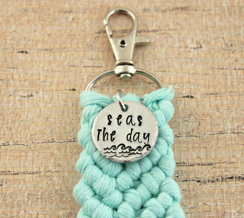 May include: A teal blue crocheted keychain with a silver charm that says "Seas the day" with a wave design.