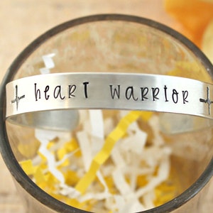 May include: Silver bracelet with an engraved heartbeat and the words "heart warrior".