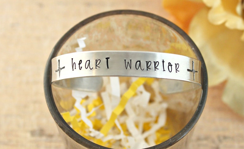 May include: Silver bracelet with an engraved heartbeat and the words "heart warrior".