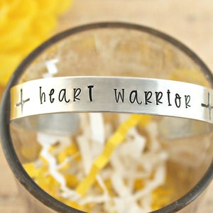 May include: Silver bracelet with a heart beat symbol and the words "heart warrior" engraved on it.