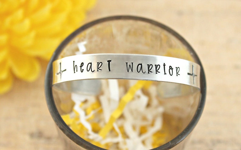 May include: Silver bracelet with a heart beat symbol and the words "heart warrior" engraved on it.