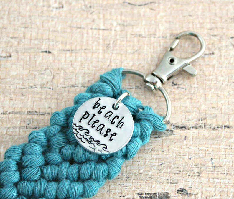 May include: Teal crocheted keychain with a silver charm that says "beach please" with a wave design.