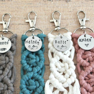 May include: Four crocheted keychains with personalized metal tags. The keychains are in grey, teal, white, and pink. The tags read "Lauren", "Melody", "Katie", and "Amber".