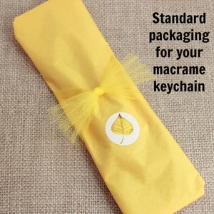 May include: A yellow macrame keychain wrapped in yellow tissue paper with a yellow tulle bow and a leaf sticker.  Standard packaging for your macrame keychain.