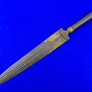 May include: A long, thin, silver dagger with a wooden handle. The blade is decorated with gold filigree.