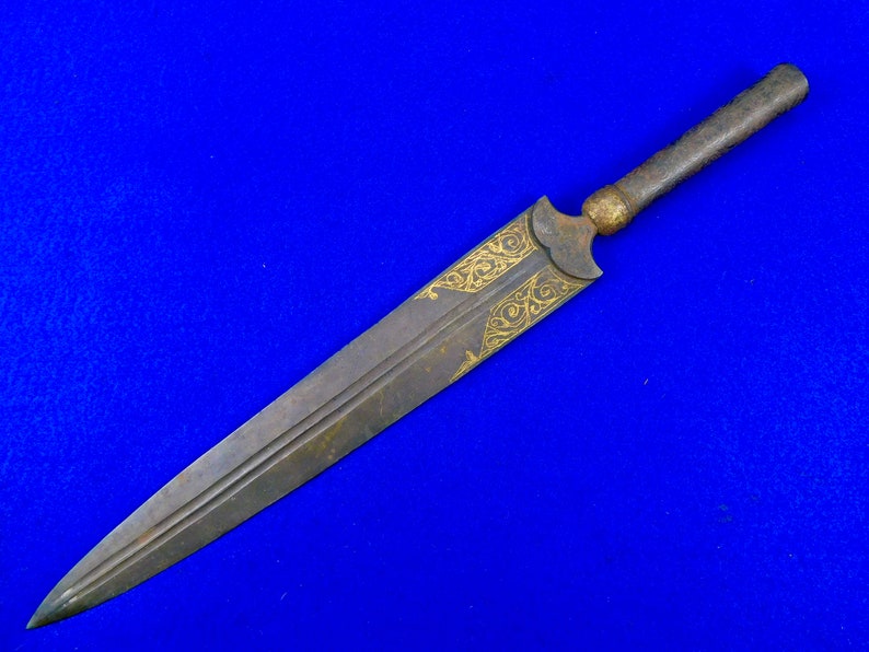 May include: A long, thin, silver dagger with a wooden handle. The blade is decorated with gold filigree.