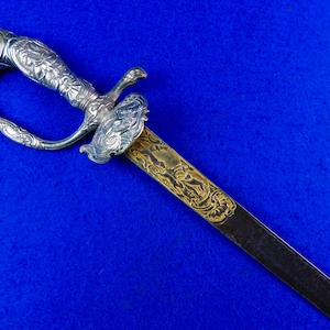 May include: A silver and gold-plated sword with an ornate handle and a blade decorated with floral patterns.