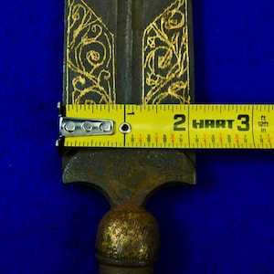May include: A gold and black metal spear with intricate floral designs. The spear is 3 feet long and has a sharp point.