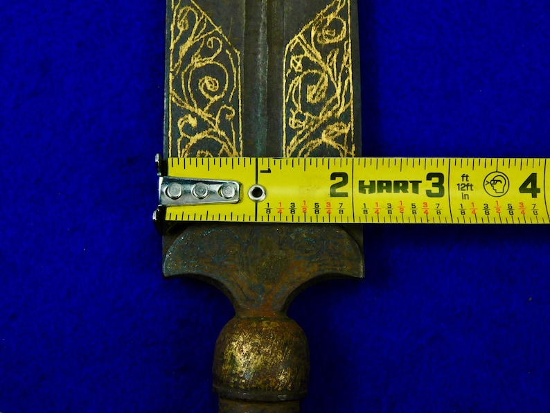 May include: A gold and black metal spear with intricate floral designs. The spear is 3 feet long and has a sharp point.