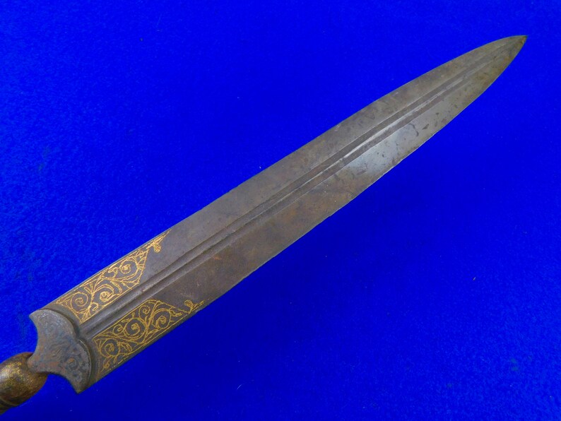 May include: A long, thin, silver-colored dagger with a gold-colored design on the blade. The dagger has a wooden handle.