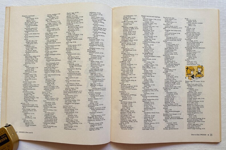 K&ouml;nnte beinhalten: Offene Buchseiten mit einer Liste von Rezepten und Zutaten. Der Text ist in schwarzer Schrift auf cremefarbenem Hintergrund. Eine kleine Illustration von zwei M&auml;dchen befindet sich in der Ecke. Das Buch ist auf einer wei&szlig;en Oberfl&auml;che ge&ouml;ffnet.