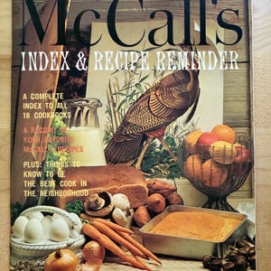 K&ouml;nnte beinhalten: Ein Vintage-Magazin-Cover von McCall's Index & Recipe Reminder. Das Cover zeigt eine Truthahn-Illustration, einen Obstkorb, Brot, Gem&uuml;se und den Text "INDEX & RECIPE REMINDER". Das Magazin verspricht ein vollst&auml;ndiges Verzeichnis von Kochb&uuml;chern und McCall's-Rezepten.
