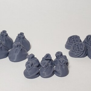 May include: A collection of 17 gray, 3D printed, miniature cloth sacks. Some of the sacks are empty, while others are filled with coins.