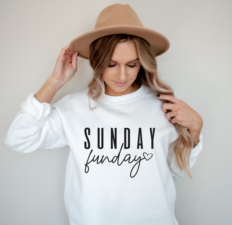 May include: White sweatshirt with black text that reads "SUNDAY funday" with a small heart symbol.