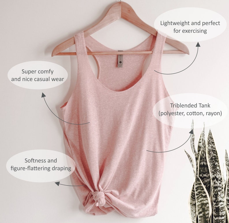 May include: A pink sleeveless tank top made from a blend of polyester, cotton, and rayon. The tank top is hanging on a wooden hanger and has a knotted bottom.
