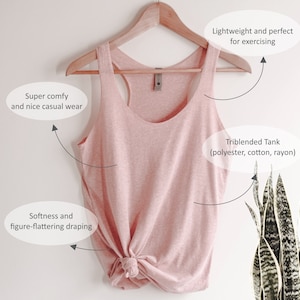 K&ouml;nnte beinhalten: Ein hellrosa Tanktop aus einer Mischung aus Polyester, Baumwolle und Viskose, das an einem Holzb&uuml;gel h&auml;ngt. Das Tanktop hat ein Racerback-Design und ist am unteren Ende geknotet. Der Text im Bild besagt, dass es leicht und perfekt f&uuml;r das Training ist.