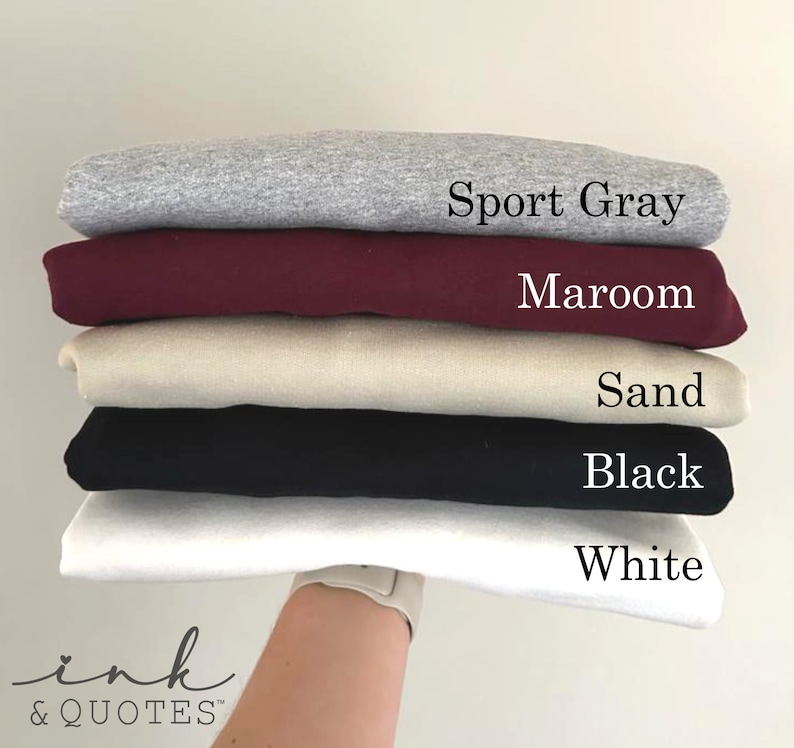 May include: Stack of five t-shirts in different colors: Sport Gray, Maroon, Sand, Black, and White.