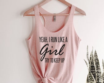 May include: Pink tank top with the text "Yeah, I run like a girl try to keep up" printed in black.