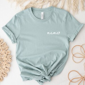 A heather dusty blue t-shirt with the word "mama" and a small heart pocket design on the front. Mama Pocket Design TShirt Minimalist Mom Gift Cute Boy Mom Shirt Trendy Girl Mama Apparel Mothers Day Gift Bella Canvas Shirt
