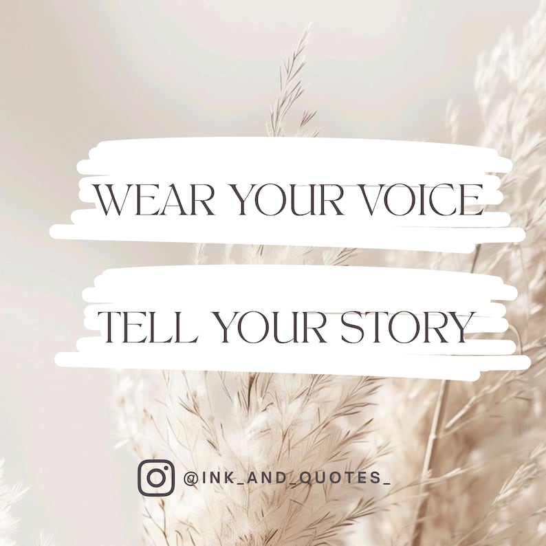 May include: A light beige background with the text "WEAR YOUR VOICE" and "TELL YOUR STORY" in a dark gray font. The Instagram handle "@ink_and_quotes_" is at the bottom. The background features blurred, feathery plants.