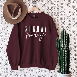 May include: Burgundy sweatshirt with white text that reads "SUNDAY funday" with a small heart symbol.