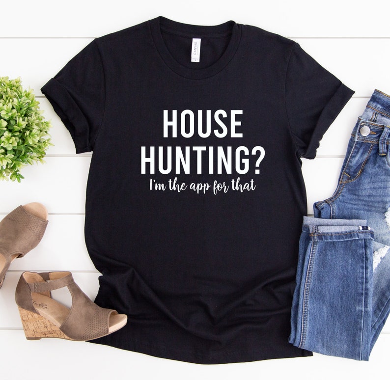 May include: Black t-shirt with white text that reads "HOUSE HUNTING? I'm the app for that."