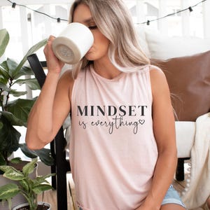 May include: A pink sleeveless shirt with the text "MINDSET is everything" in black lettering with a small heart symbol.